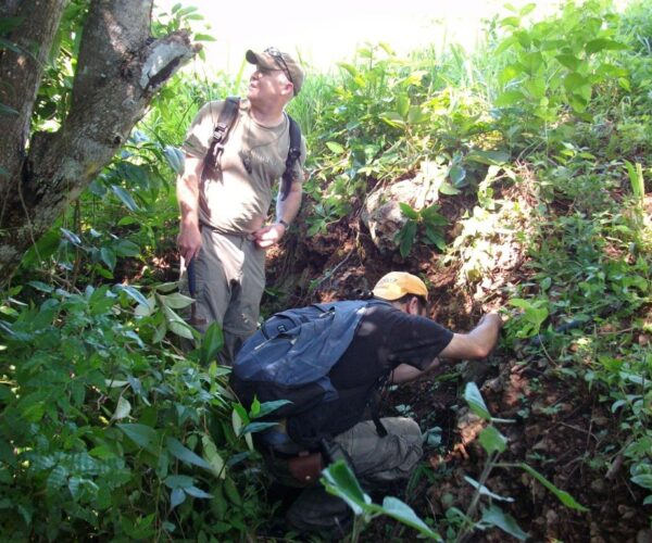 Geologists visiting a rare outcrop of gold mineralisation, rock chip sampled at 5.49gpt Au & 22.5gpt Ag (Filadelphia Prospect)